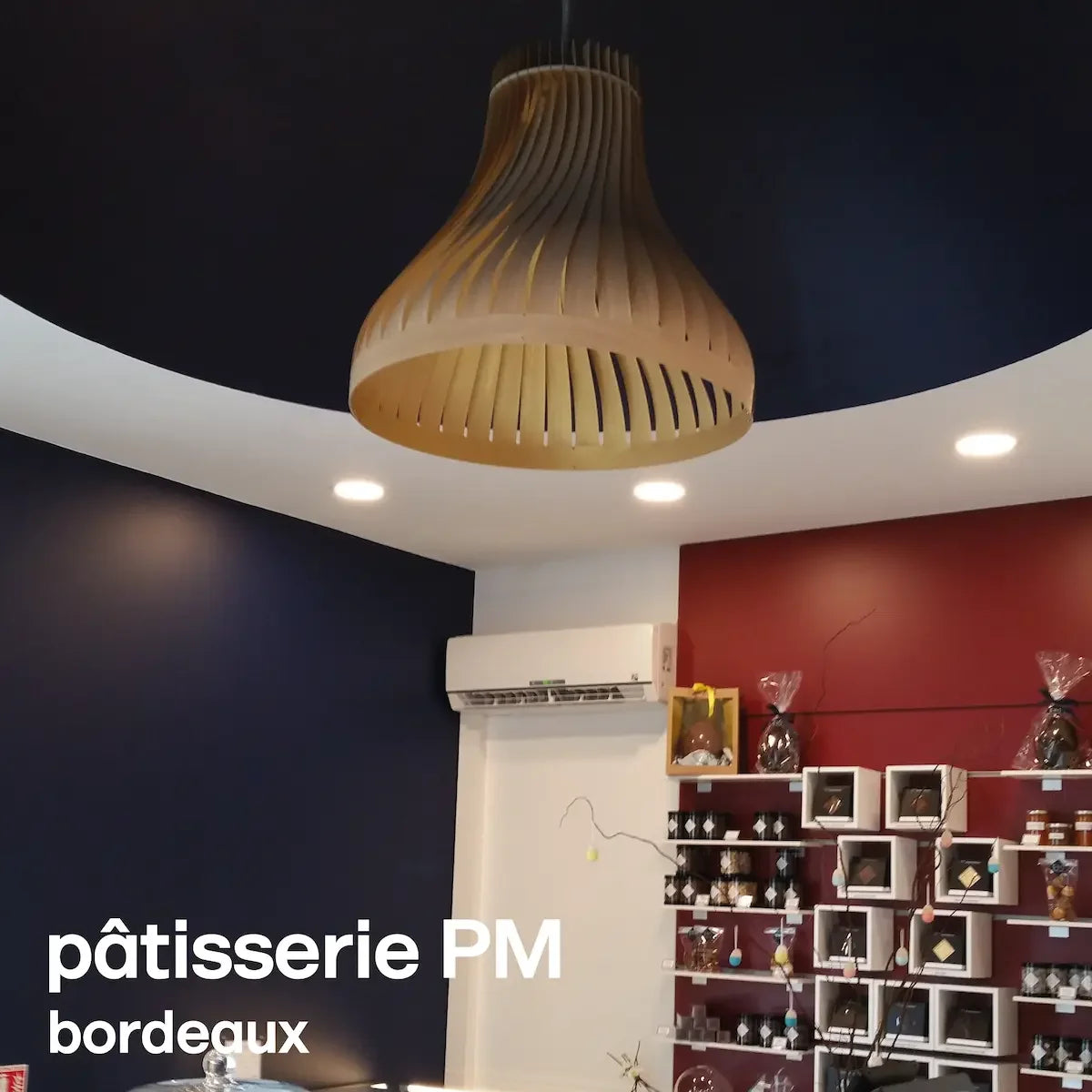 le grand lustre moderne en bois volupte xxl décore la patisserie PM à Bordeaux